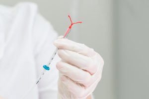 Doctor holding up IUD before insertion.