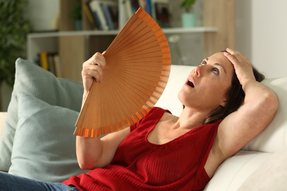 woman experiencing hotflashes–one of the 34 symptoms of menopause